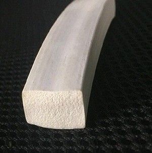Strato autoadesivo della spugna del silicone a metà intorno alla superficie regolare della striscia di gomma